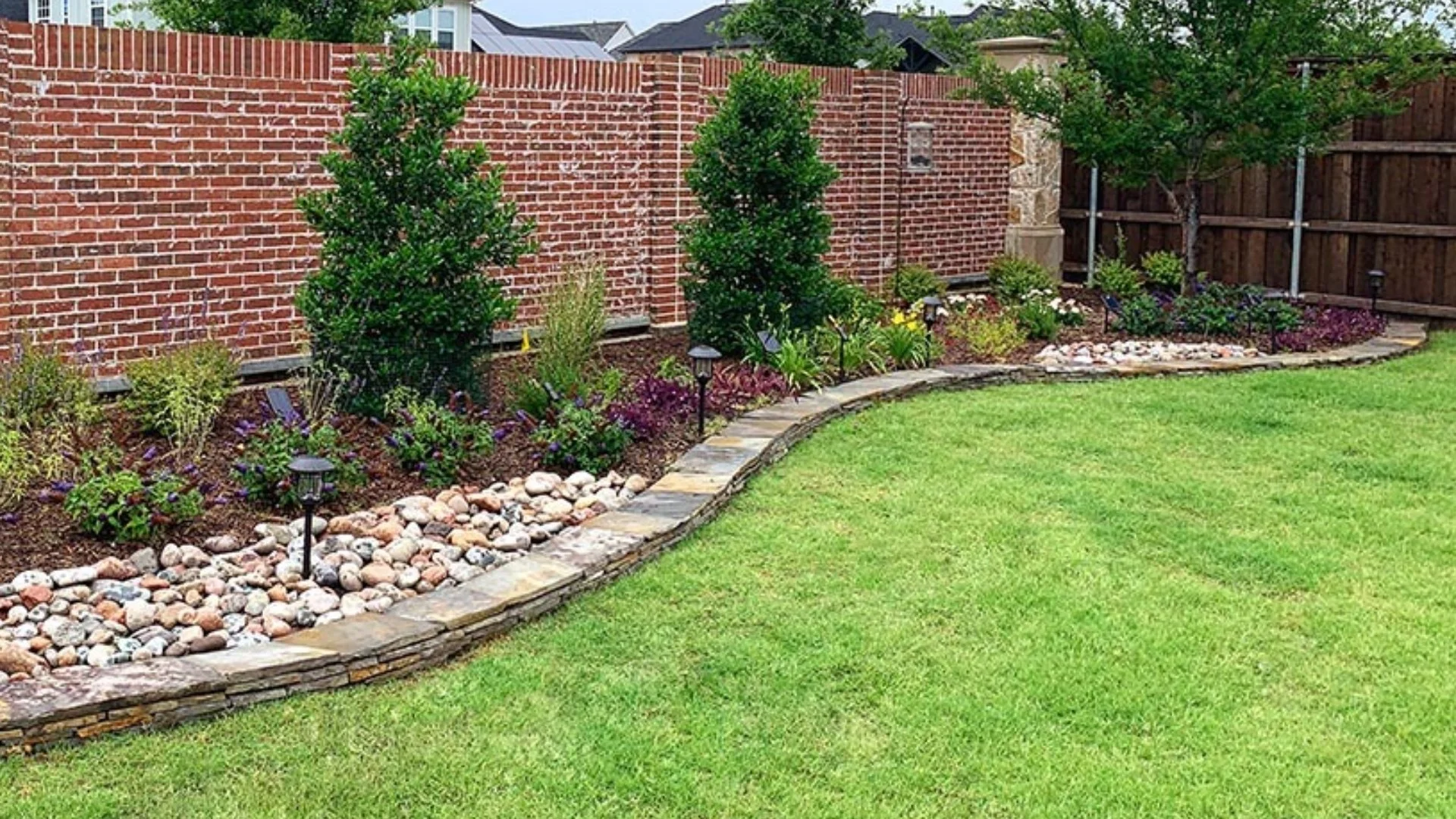 Beautiful landscape beds filled with plants and trees in Garland, TX.