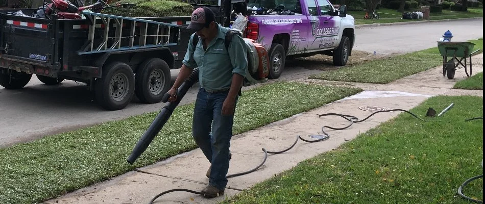 Lawn care employee blowing grass after maintenance in Plano, TX.
